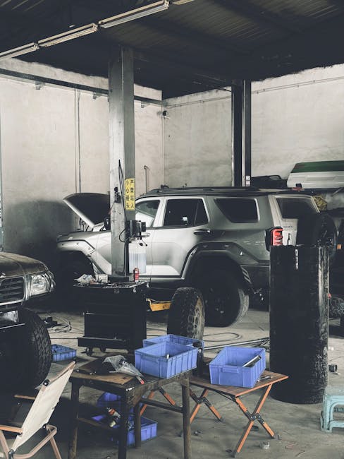 A detailed view inside a busy auto repair workshop with an SUV and various tools.
